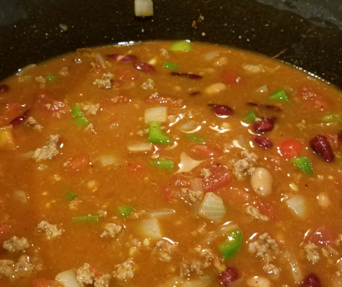 Zero point turkey chili simmering on the stove ready to be served with low fat cheese and crackers