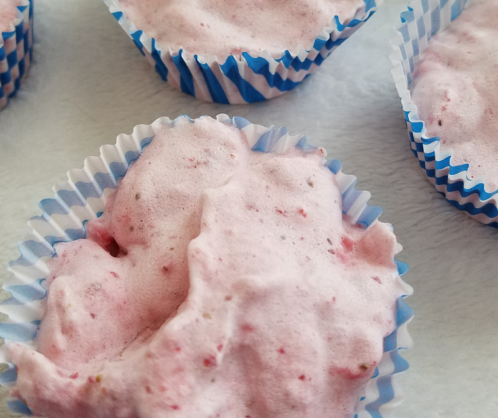 Overhead picture of strawberry fruit ice cream in cupcake liners sitting on a white surface