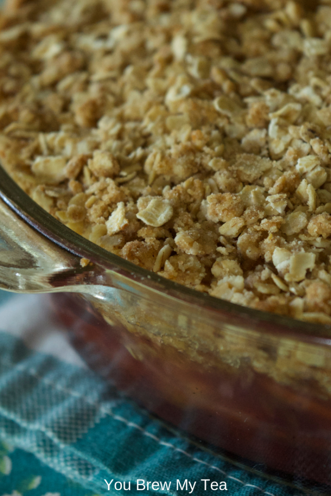 cranberry apple crisp in baking dish laying on a teal napkin