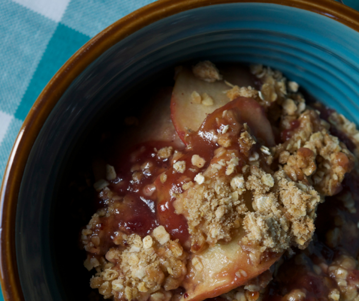 cranberry apple crisp in baking dish laying on a teal napkin