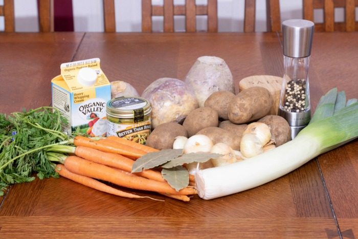 Ingredients for creamy vegetable soup laying on a kitchen table