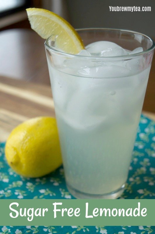 A tall glass of sugar free lemonade sitting on a wooden table and teal napkin with small flowers