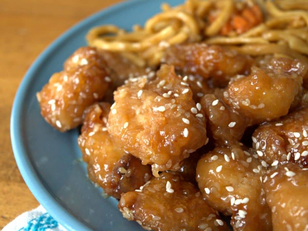 sesame chicken on blue plate on wood table