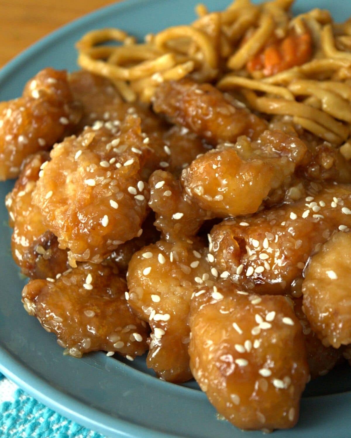 chicken nuggets with sesame seeds on blue plate with noodles