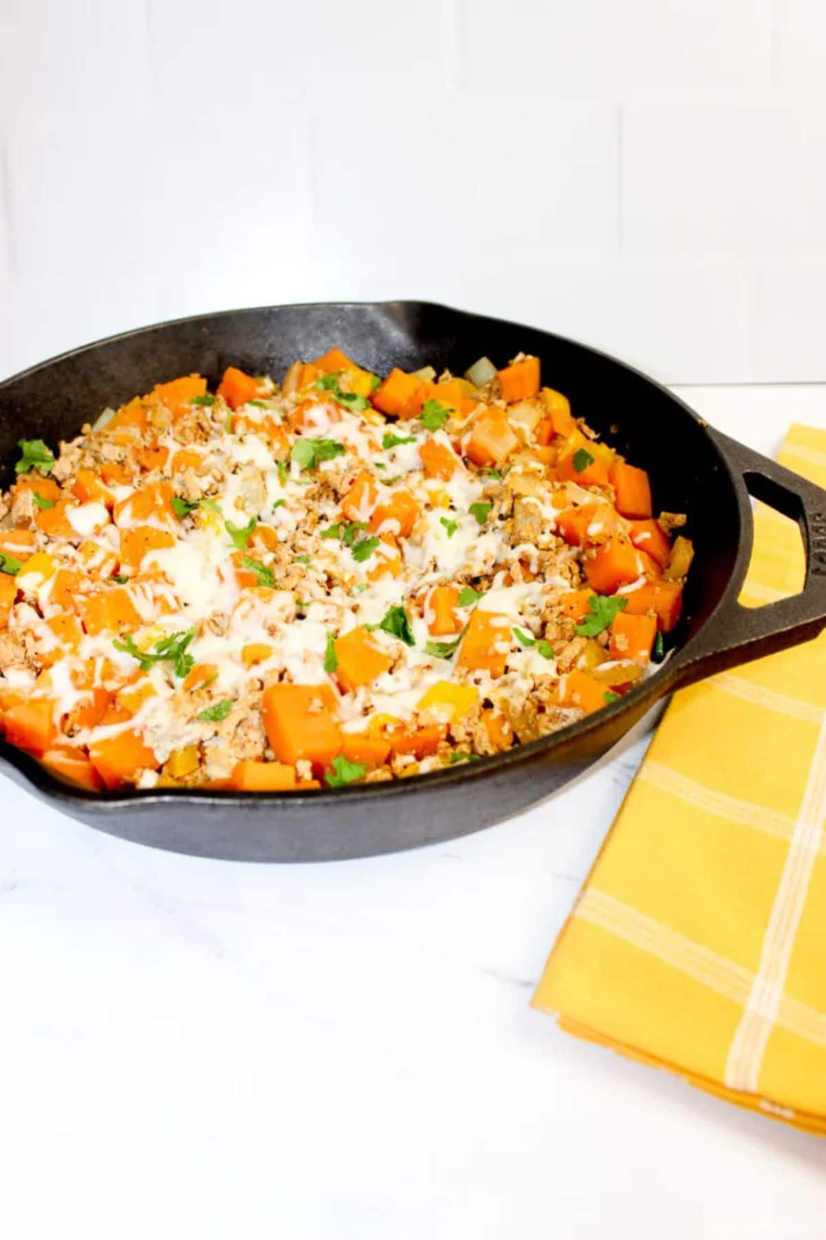 cast iron skillet with turkey potatoes and cheee