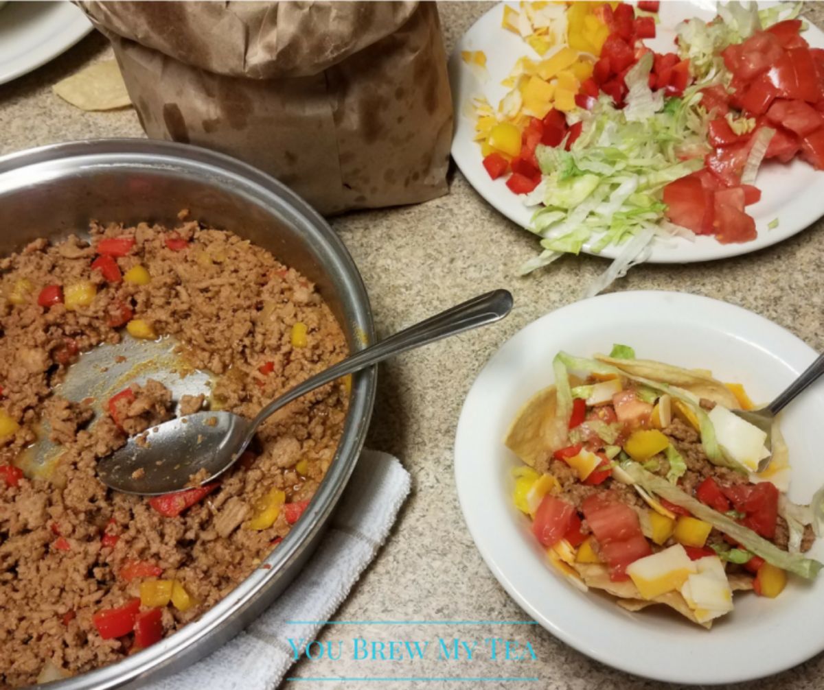 white bowls of taco on table next to silver skillet