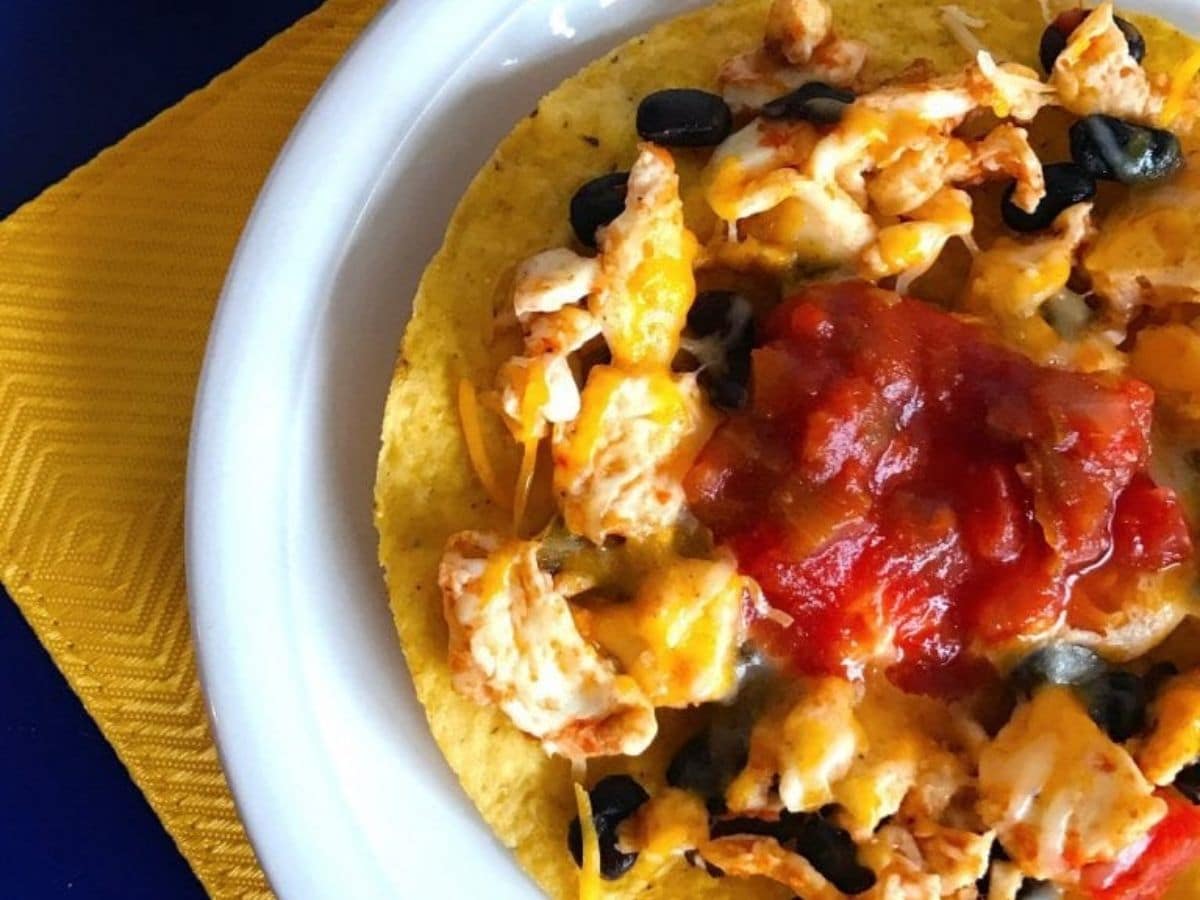 tostada on white plate with salsa on top