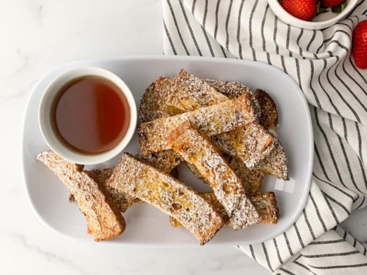 french toast on white platter with white bowl of syrup