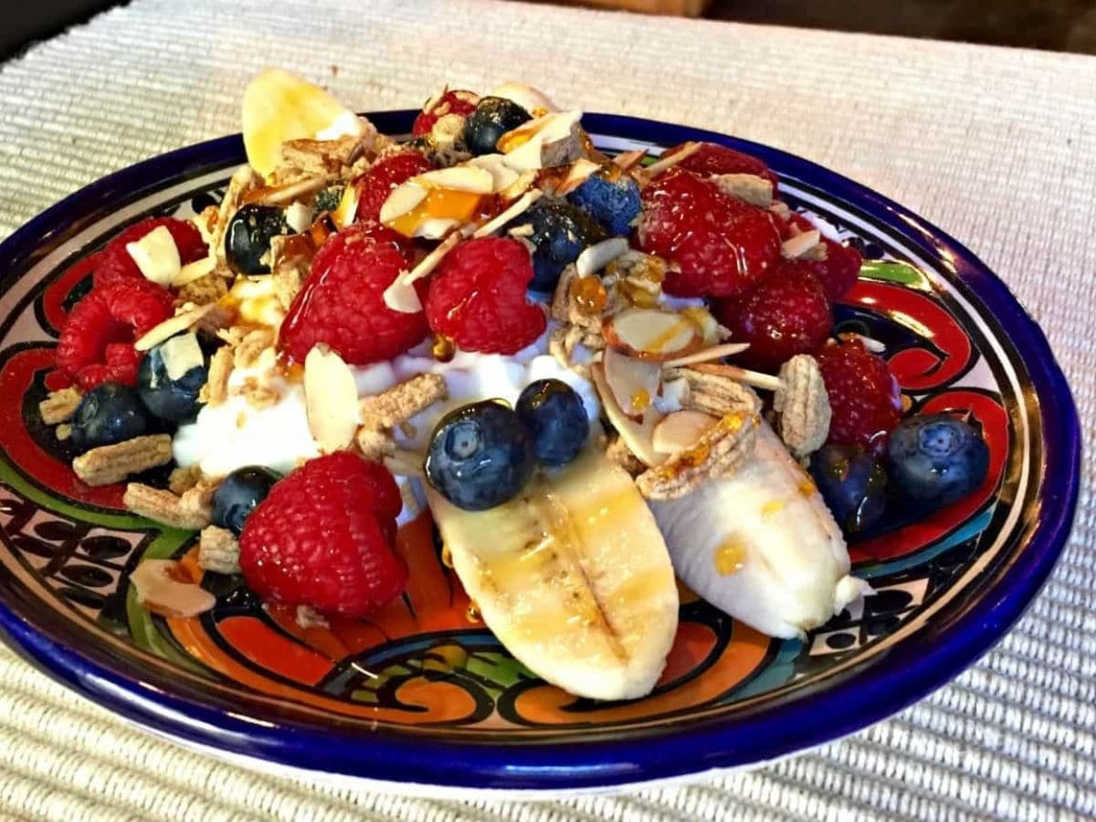 banana split with berries on colorful plate