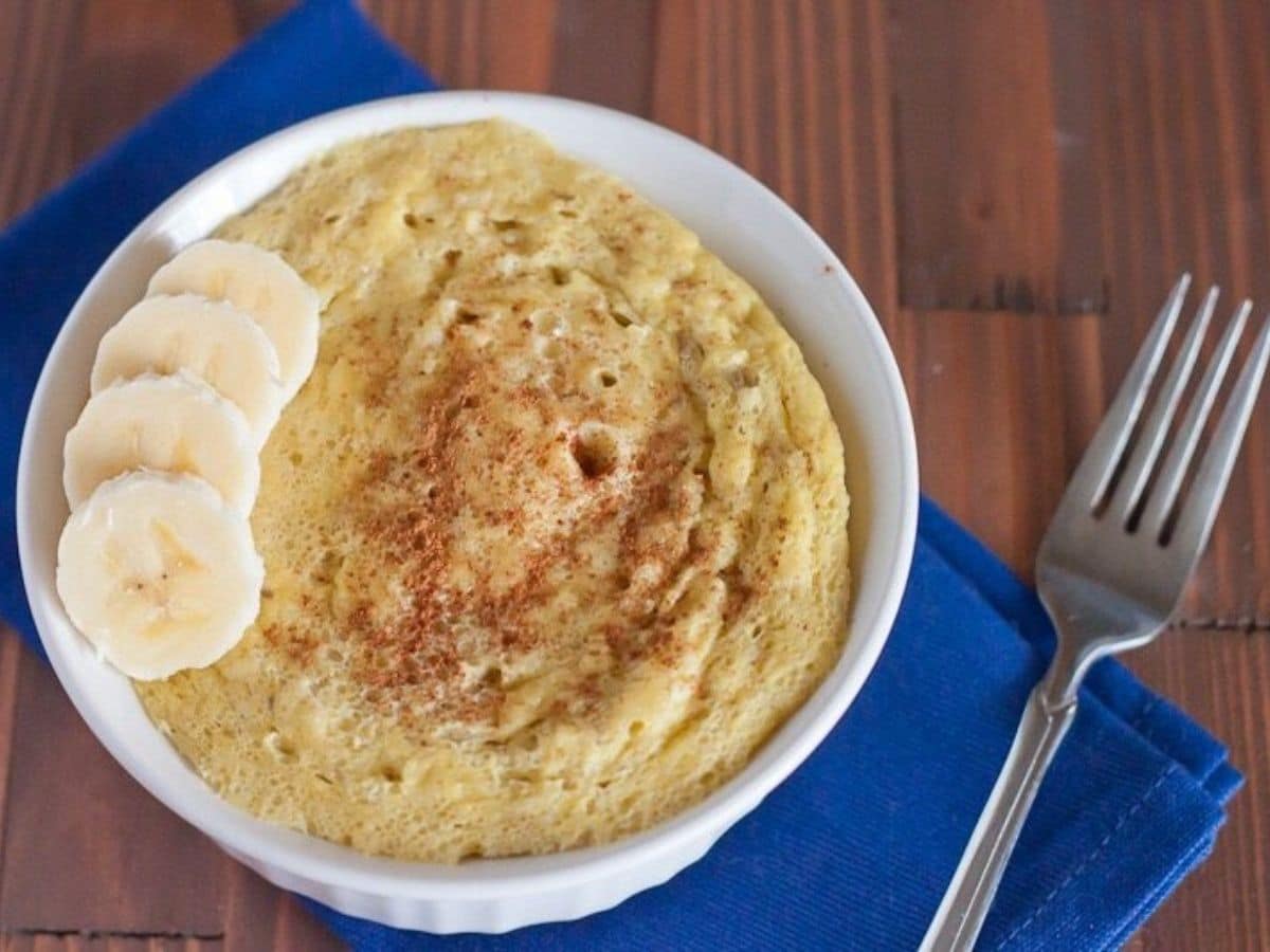 souflle in white bowl on blue napkin with sliced bananas on top