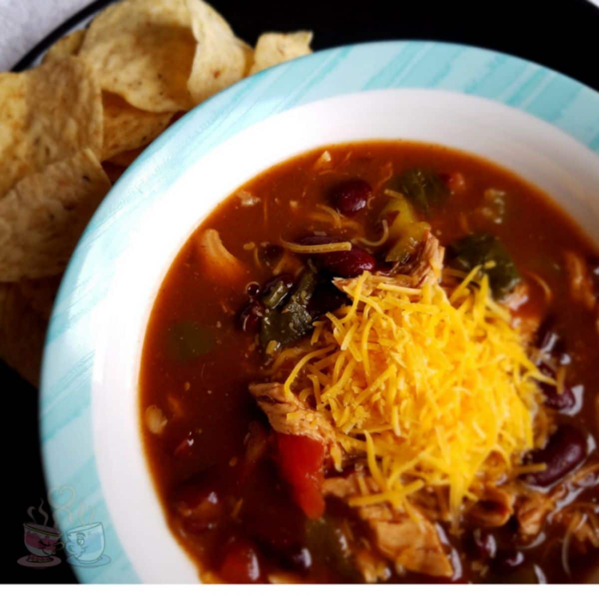 white and blue bowl of soup with cheese on top