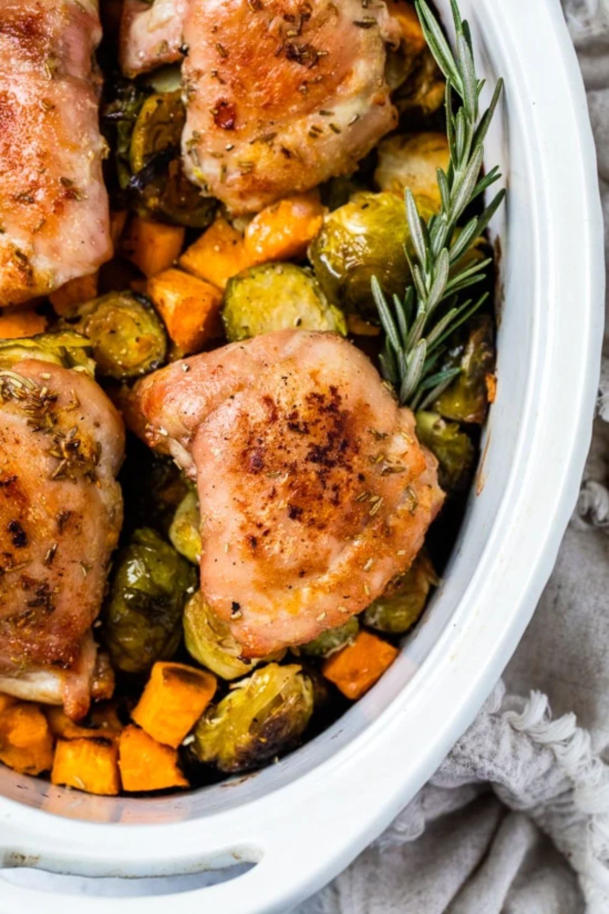 chicken thighs and veggies in white casserole dish