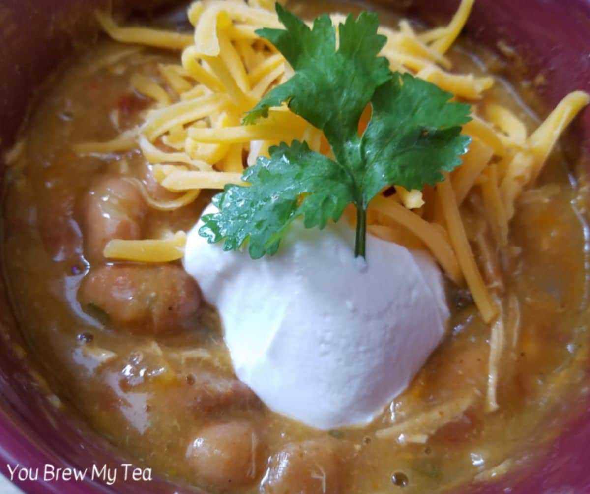 tortilla soup in red bowl with sour cream and cilantro