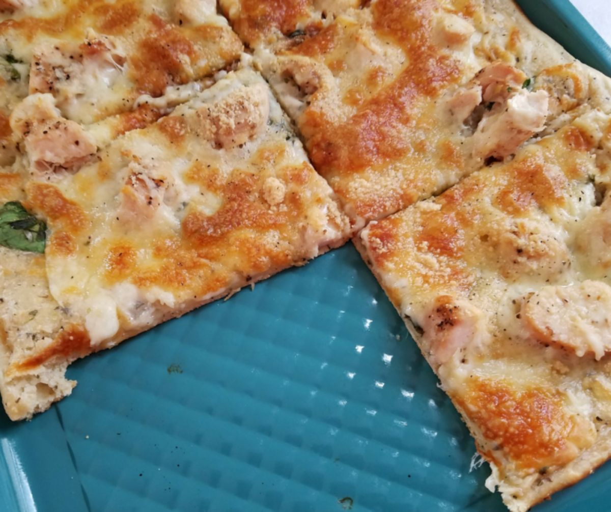 pizza sliced on teal baking sheet