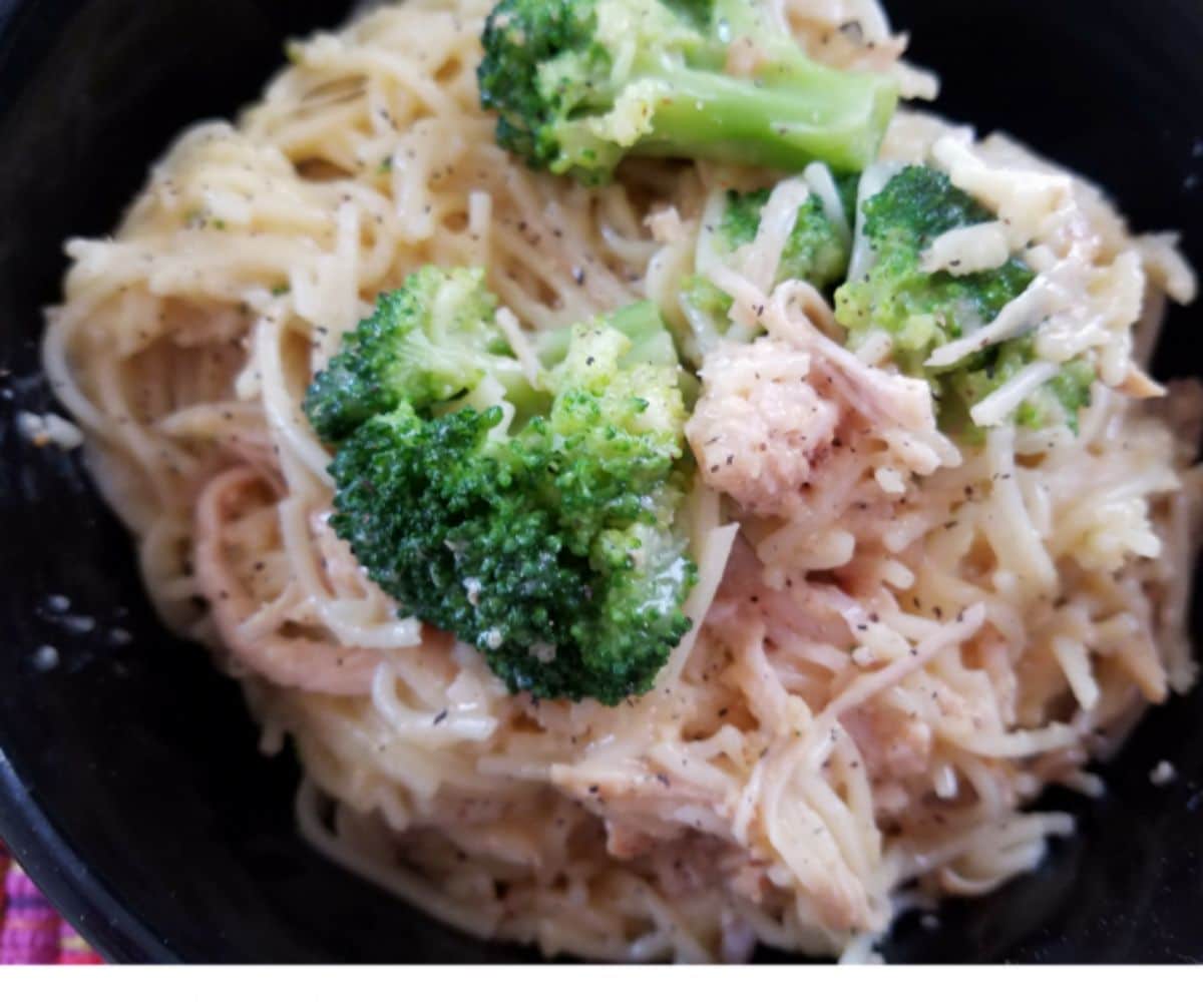 broccoli on top of pasta in black bowl