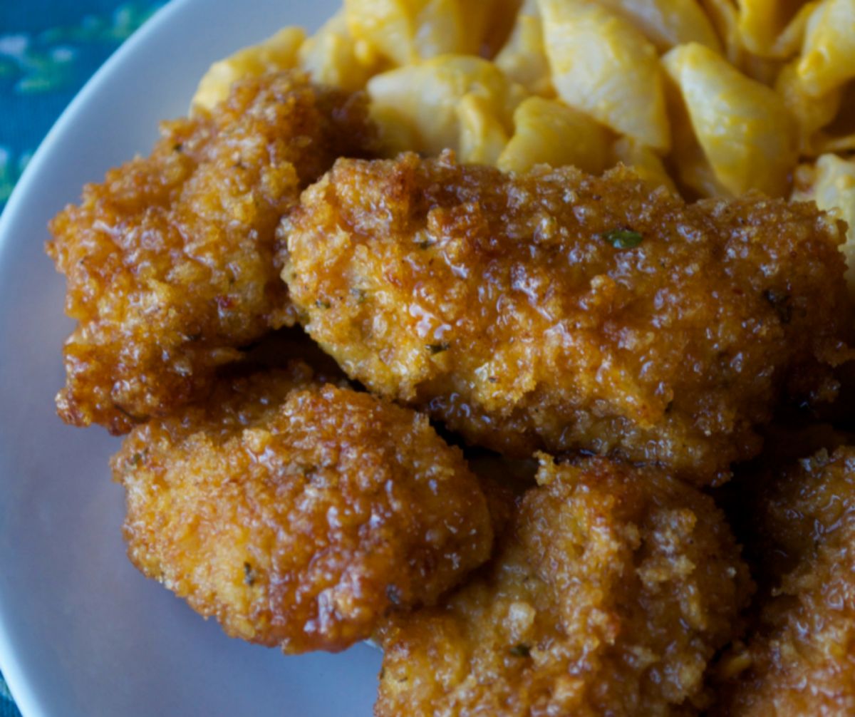 chicken tenders with macaroni and cheese on blue plate