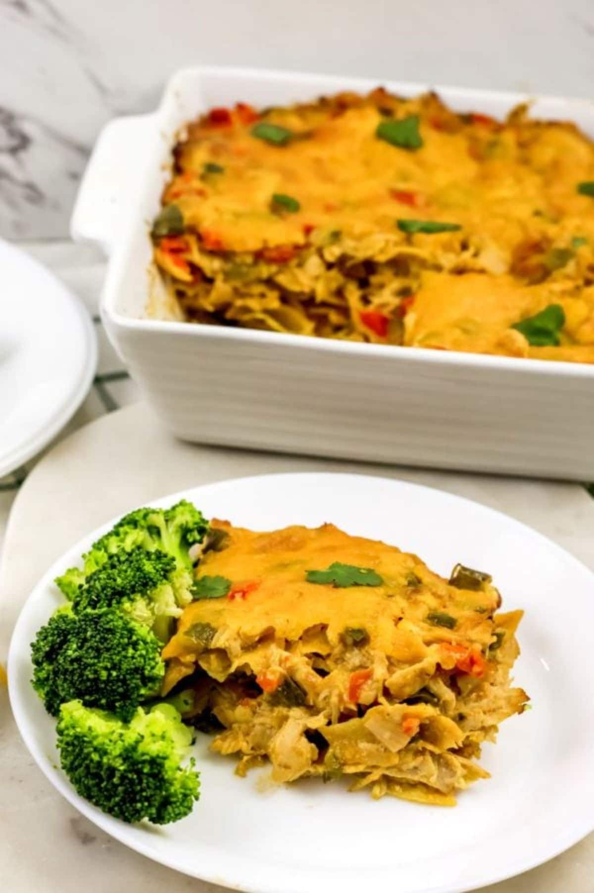 casserole and broccoli on white plate by baking dish