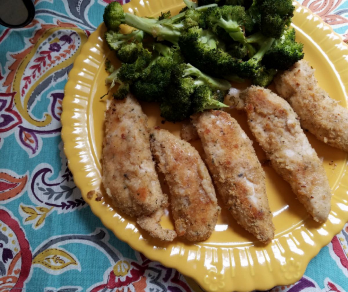 chicken and broccoli on yellow plate on colorful nakpin