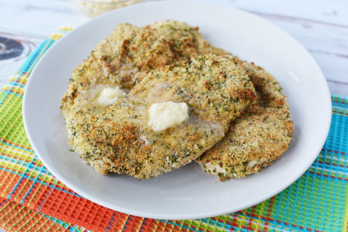 pad of butter on top of air fryer chicken breasts