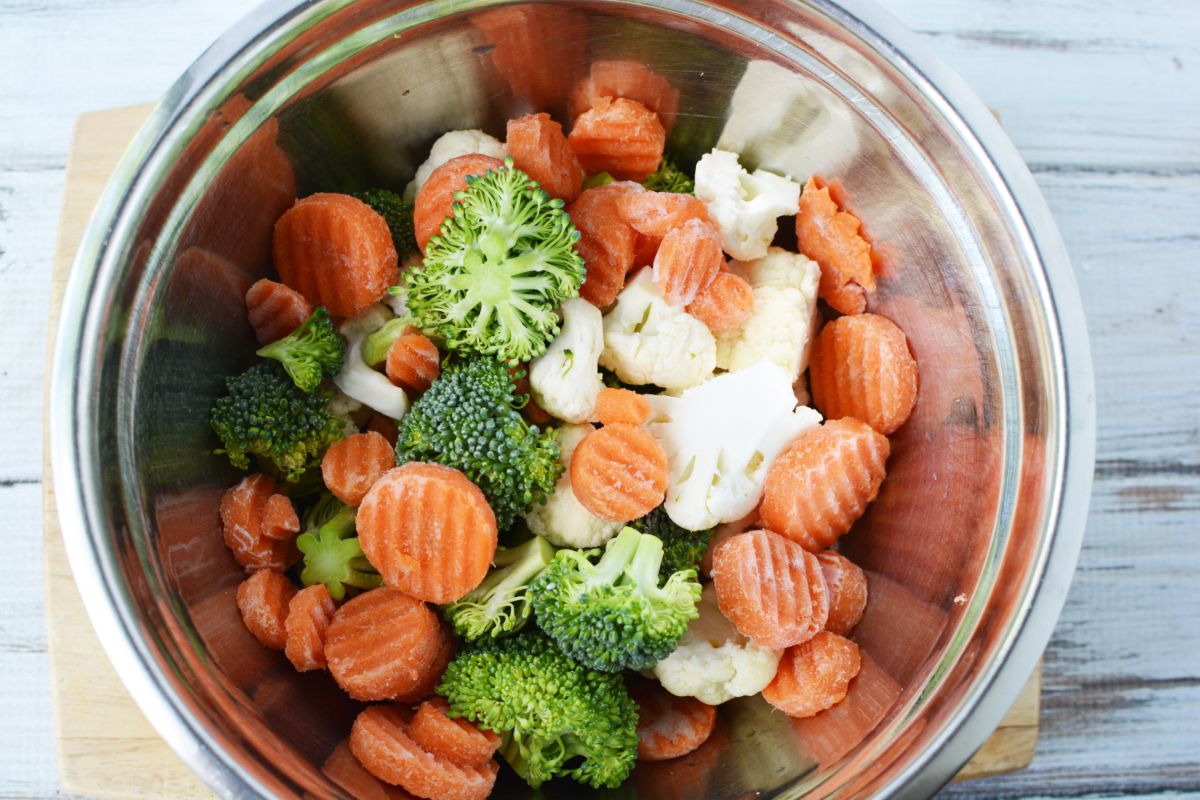 cut broccoli, cauliflower, and carrots in stainless steel bowl on counter